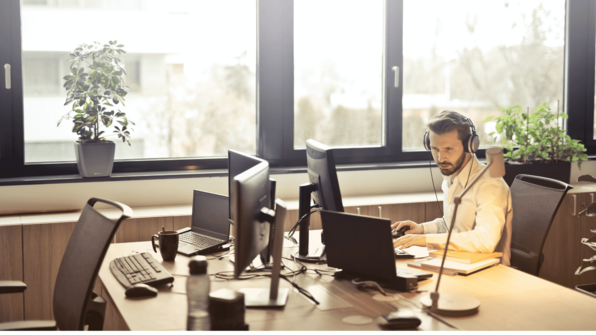 Man zit op bureau met een koptelefoon op