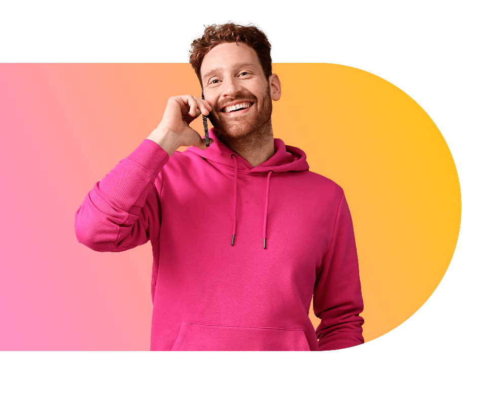 Robert van Rinkel is glimlachend aan het telefoneren in casual kleding met gele-roze gradient op de achtergrond