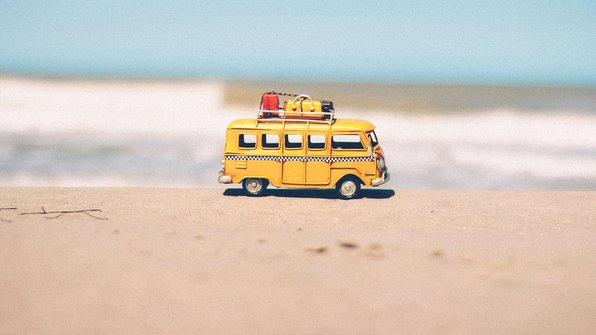 Klein oud busje op het strand