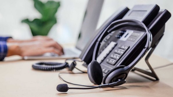 VoIP telefoon met headset op een bureau