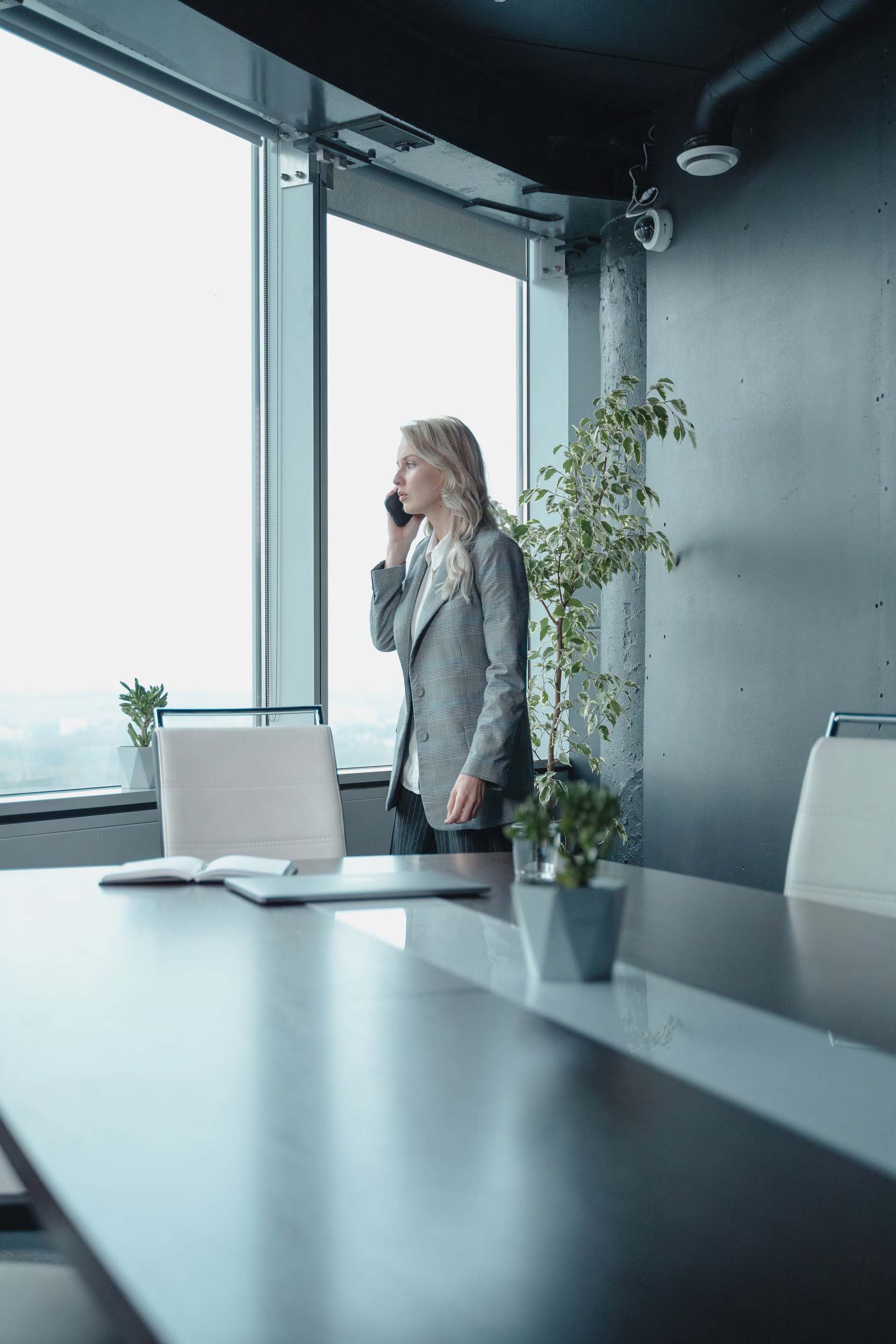 Vrouw telefoneert in een vergaderkamer